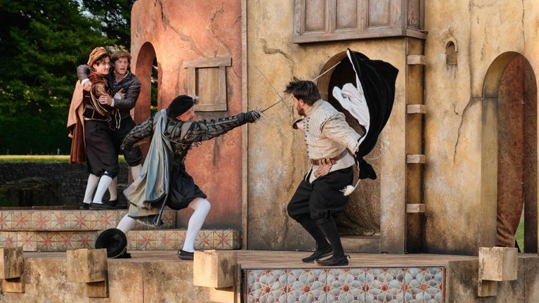 A sword fight in action during on a set resembling the exterior of an old house, during a performance of Romeo Juliet at Glastonbury Abbey
